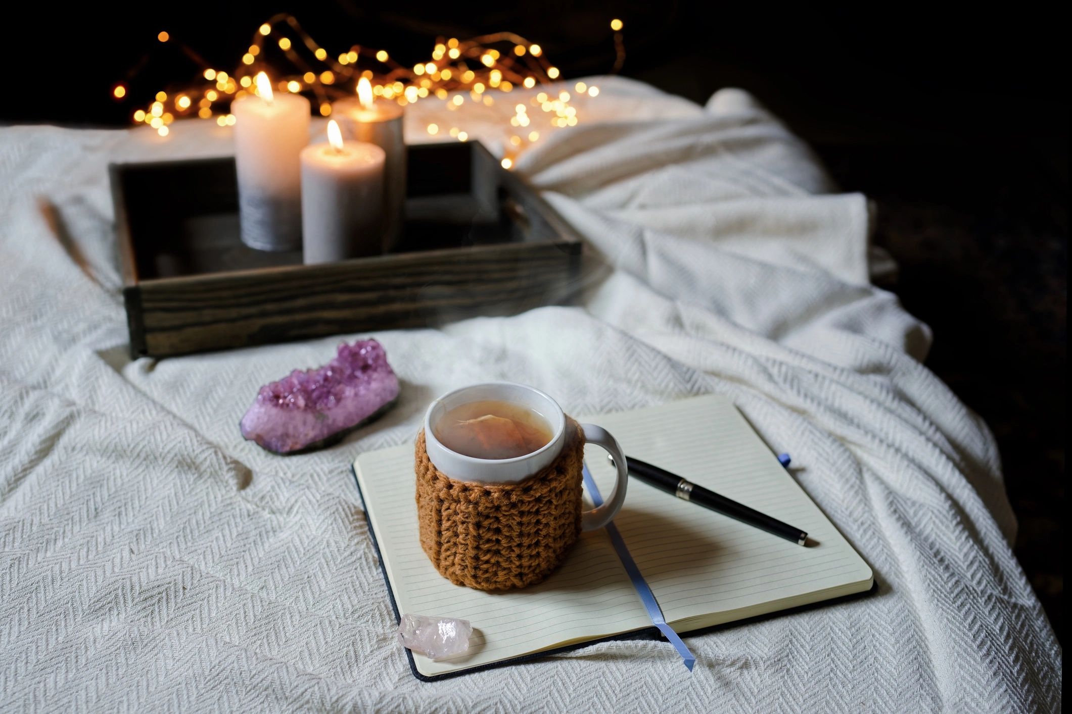 Journal and tea on a cozy table, representing reflection and nervous system downshifting